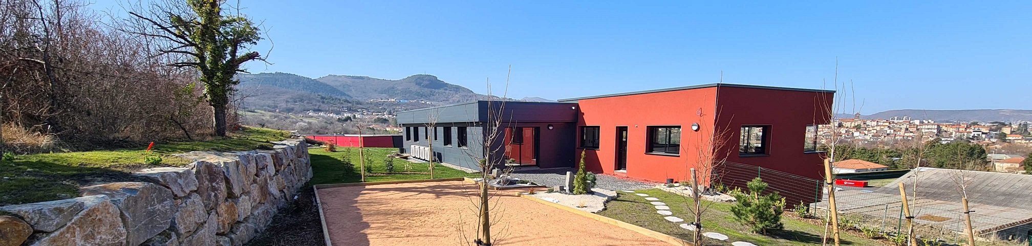 photo d'un bâtiment professionnel noir et rouge avec un jardin